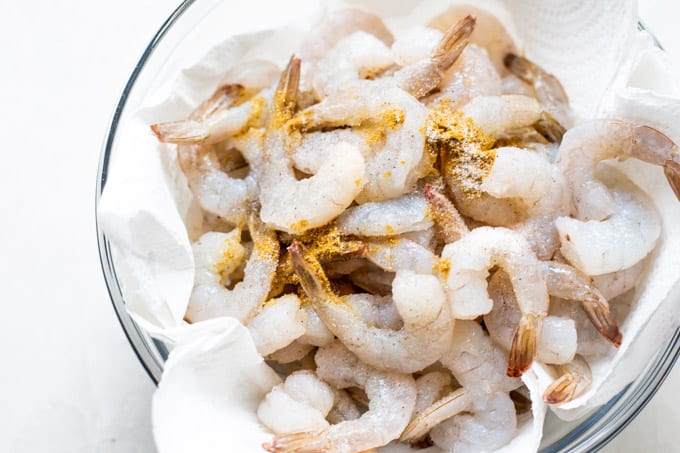 Raw shrimp sprinkled with seasoning.