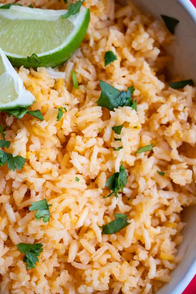 Mexican Rice, arroz rojo, sprinkled with chopped cilantro and two lime wedges. 