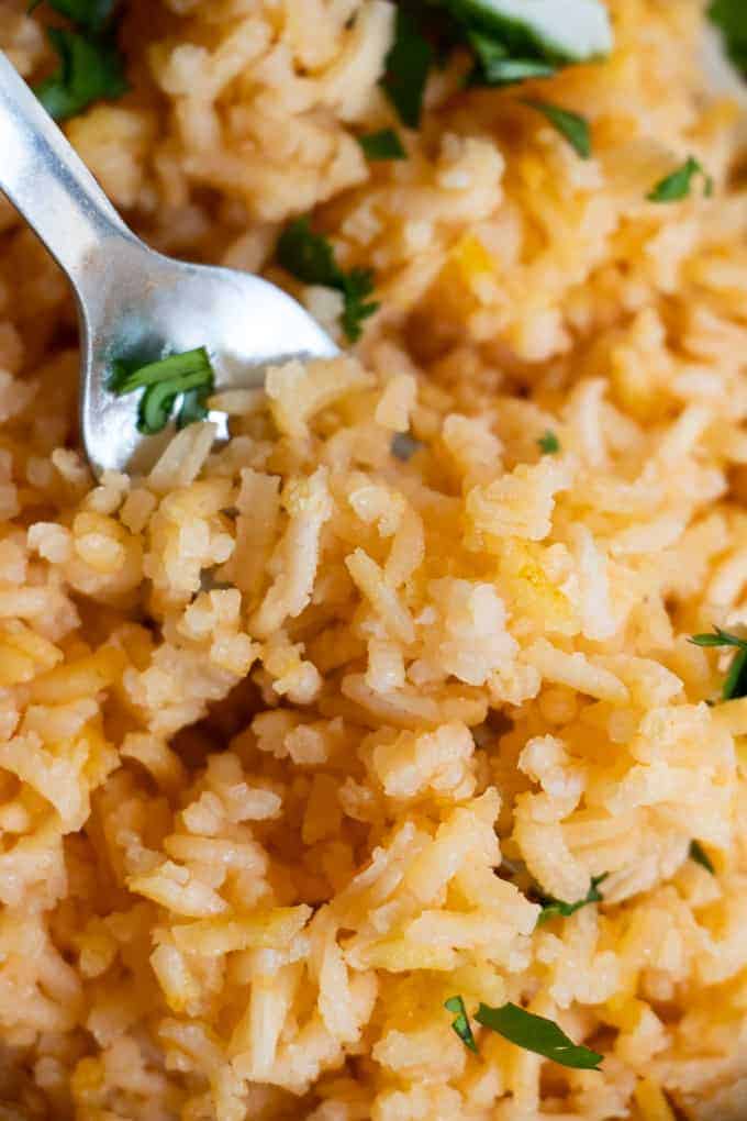 Close up view of Mexican Rice or Arroz Rojo, showing the fluffy texture and pale red color of the rice. 