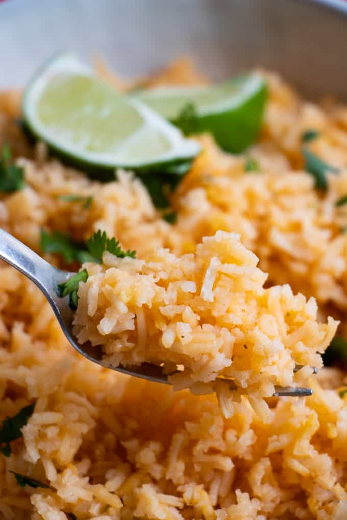 A fork lifting a bite of mexican Spanish rice. 