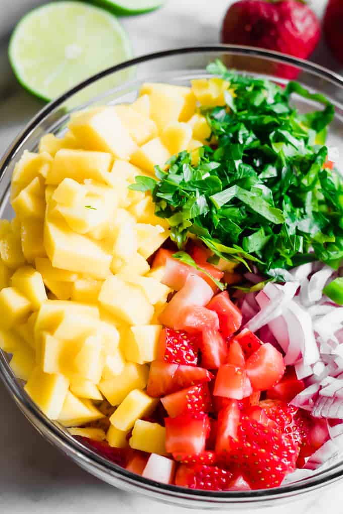 All the ingredients for the strawberry mango salsa in a glass bowl prior to stirring. 