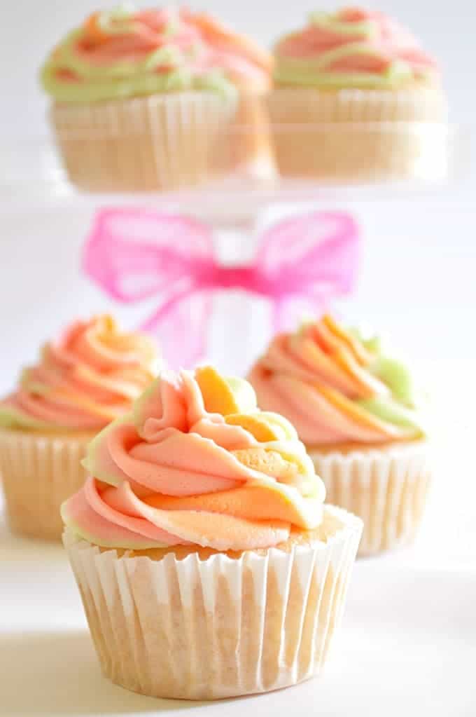 These Rainbow Sherbet Cupcakes are made with real rainbow sherbet in the cake batter and topped with three flavors of swirled frosting! #houseofyummth three flavors of swirled frosting! #houseofyumm