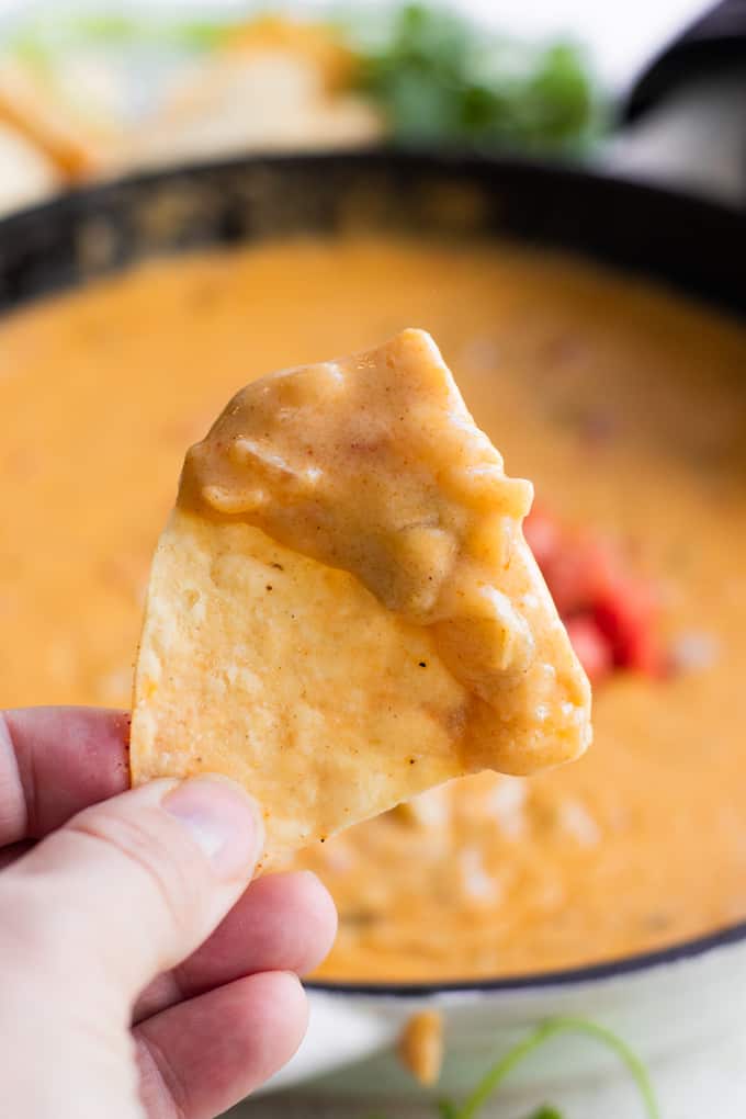 A chip coated in creamy homemade queso. 