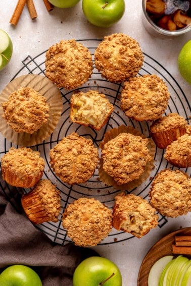 Apple muffins with a crumb topping on a wire cooling rack.