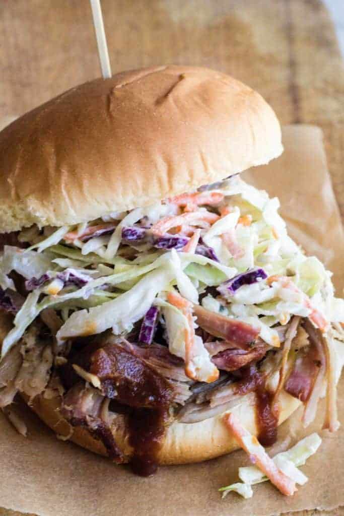 Pulled Pork sandwich on a bun topped with blue cheese coleslaw.