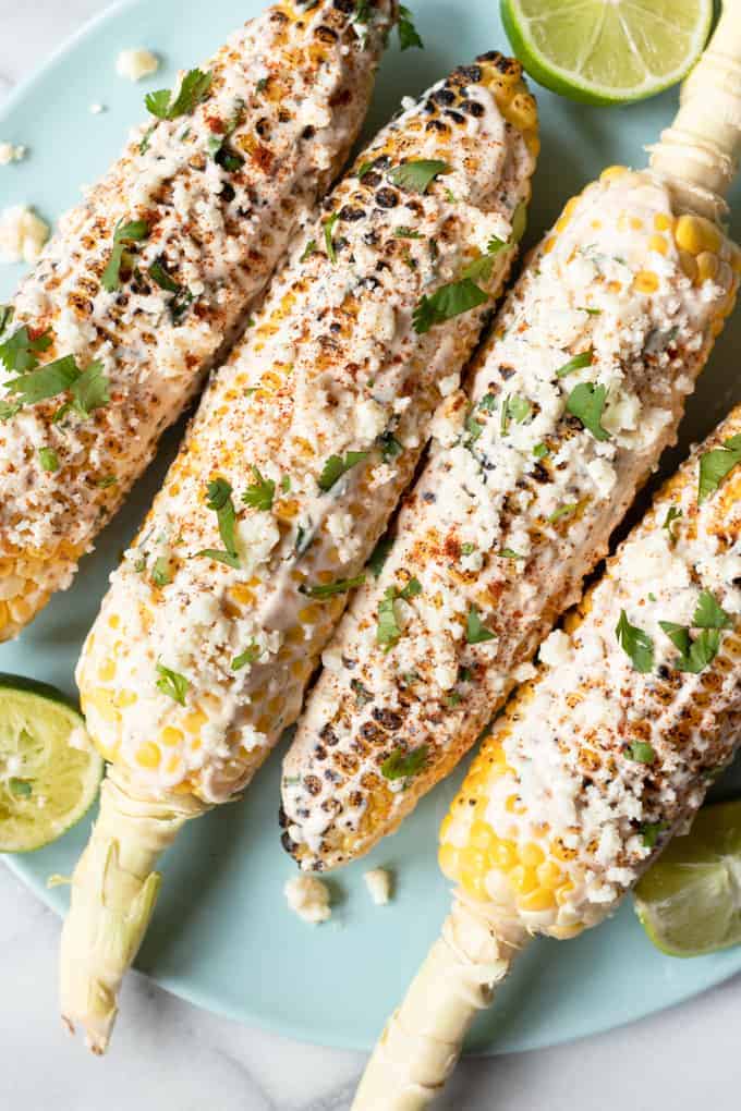 Plated Mexican street corn with lime wedges. 