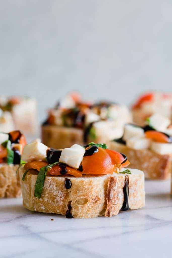 Caprese Bruschetta auf geschnittenem Baguette und mit einer Balsamico-Glasur beträufelt.