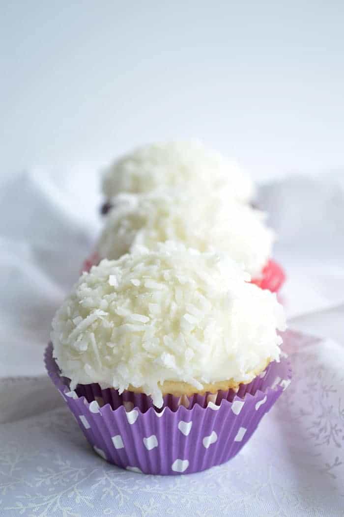 Coconut Cupcakes. A moist white coconut cake with a creamy coconut filling and coconut frosting on top! | cupcakesandkalechips.com