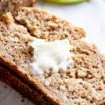 A slice of apple bread topped with a pad of melting butter.