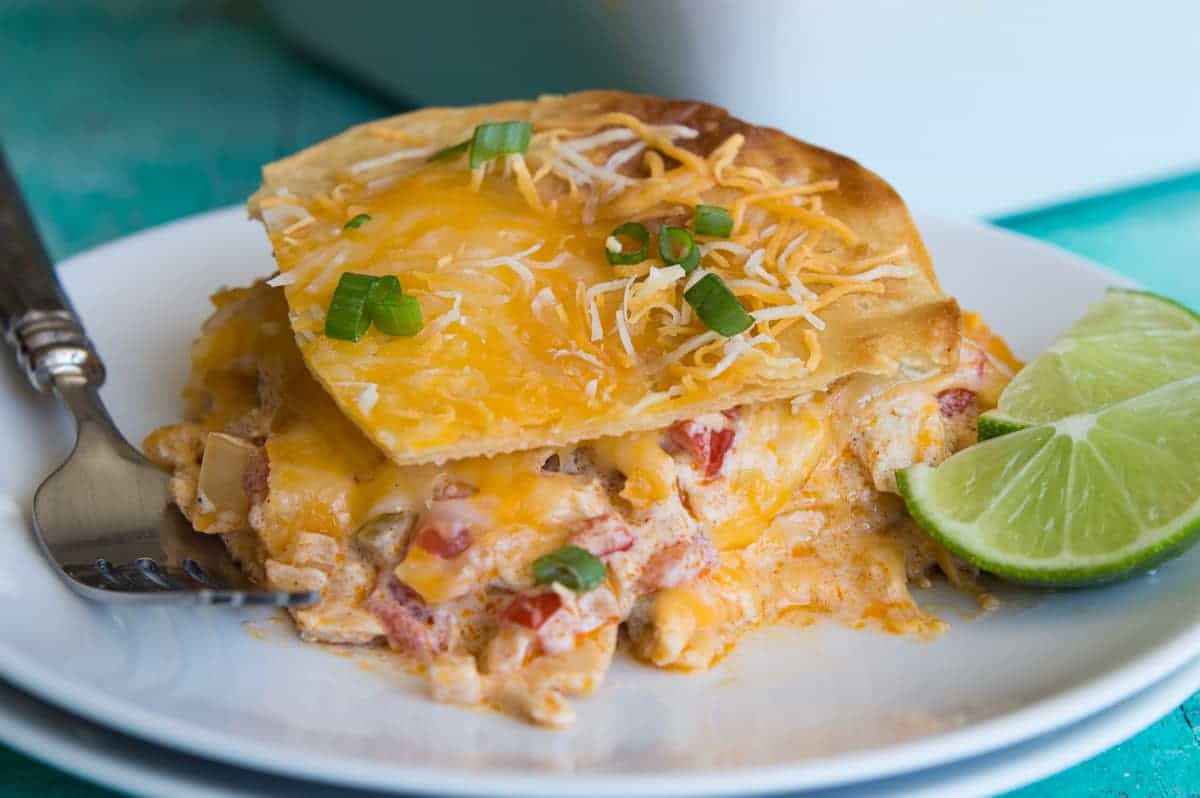 King Ranch Chicken Casserole! This cheesy casserole is basically a Texan lasagna! Layers of crispy corn tortillas, cheese, and a creamy chicken mixture loaded with bell peppers, tomatoes, green chiles, chili powder and cumin! Perfect for potlucks or family get togethers!