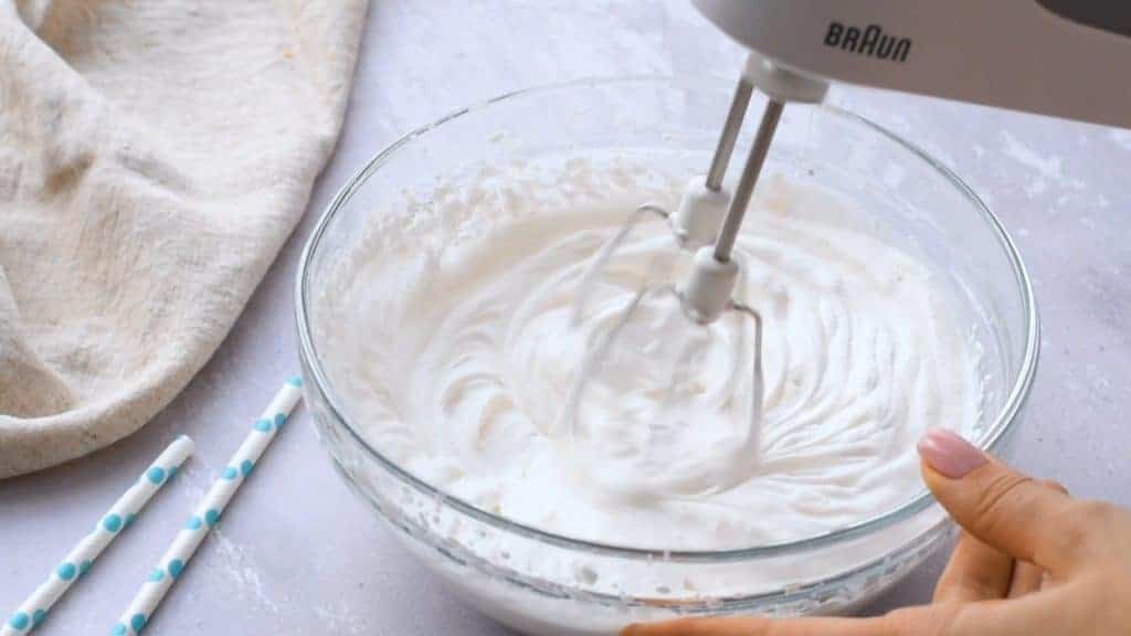 Hand mixer making homemade whipped cream.
