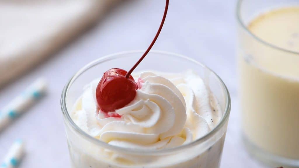 Warm Vanilla bean steamer topped with whipped cream and a cherry.