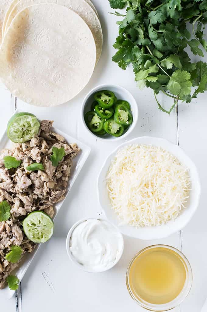 Tequila Lime Chicken Enchiladas with a Creamy Jalapeño Cilantro Sauce. These enchiladas are SO flavorful! Full of tender tequila lime chicken, cheese, and topped with a cheesy, creamy jalapeño cilantro sauce. 