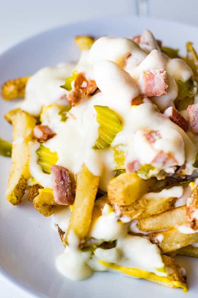 Crispy french fries loaded with all the flavors of a Cuban sandwich and topped with a creamy swiss cheese sauce! The ULTIMATE appetizer or snack recipe! A definite crowd pleaser!