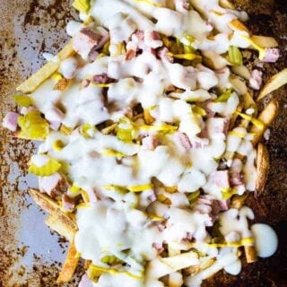 Crispy french fries loaded with all the flavors of a Cuban sandwich and topped with a creamy swiss cheese sauce! The ULTIMATE appetizer or snack recipe! A definite crowd pleaser!