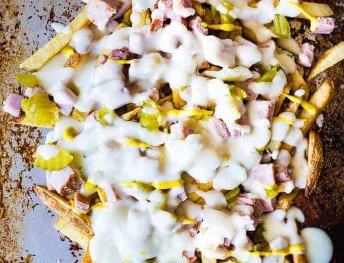 Crispy french fries loaded with all the flavors of a Cuban sandwich and topped with a creamy swiss cheese sauce! The ULTIMATE appetizer or snack recipe! A definite crowd pleaser!