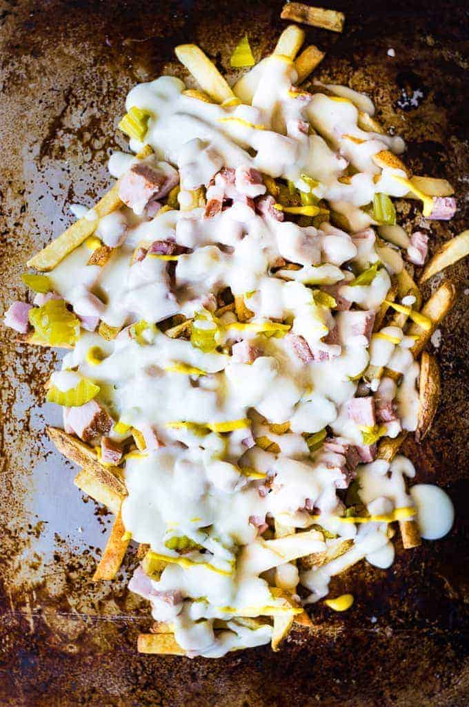 Crispy french fries loaded with all the flavors of a Cuban sandwich and topped with a creamy swiss cheese sauce! The ULTIMATE appetizer or snack recipe! A definite crowd pleaser!