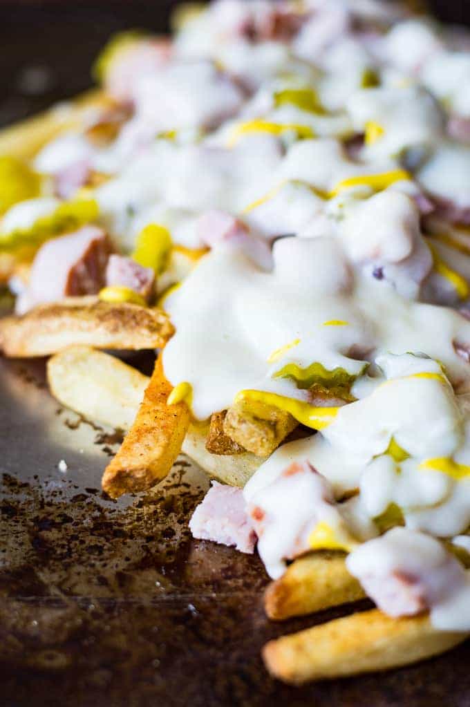 Crispy french fries loaded with all the flavors of a Cuban sandwich and topped with a creamy swiss cheese sauce! The ULTIMATE appetizer or snack recipe! A definite crowd pleaser!