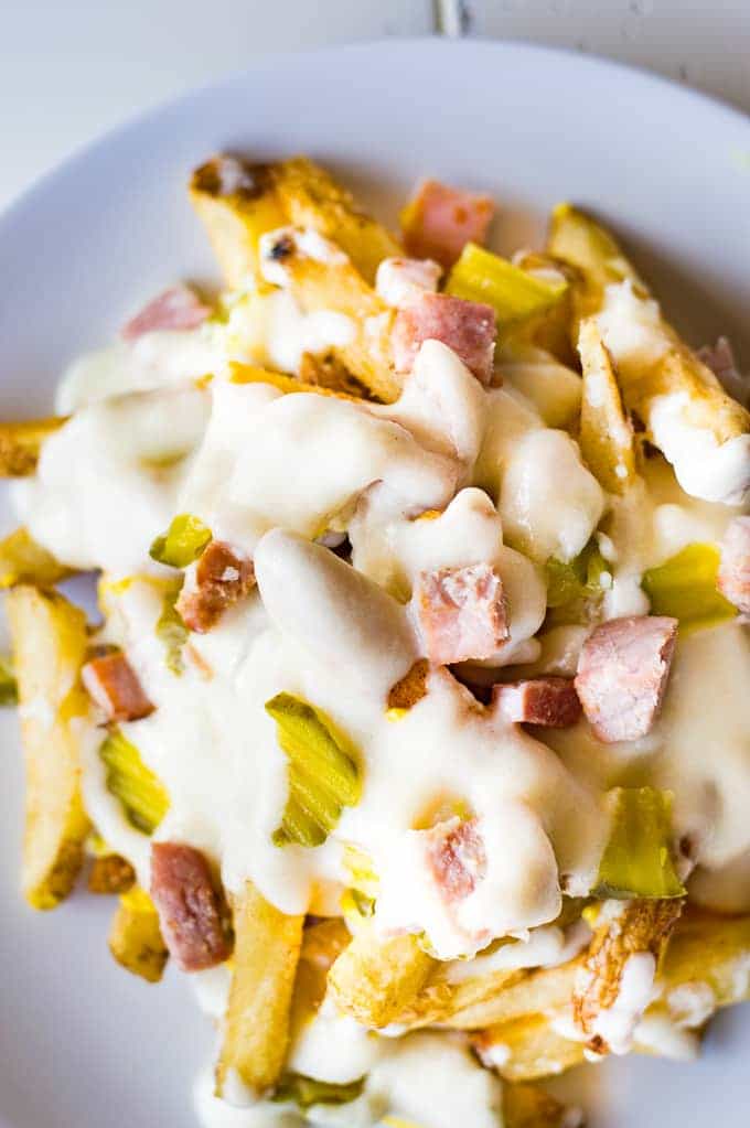 Crispy french fries loaded with all the flavors of a Cuban sandwich and topped with a creamy swiss cheese sauce! The ULTIMATE appetizer or snack recipe! A definite crowd pleaser!