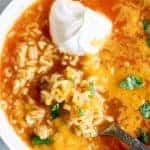 Bowl filled with Mexican Alphabet Soup, sopa de letras, and topped with sour cream, cheese and cilantro.