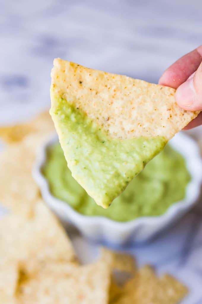 Chip coated with creamy avocado salsa