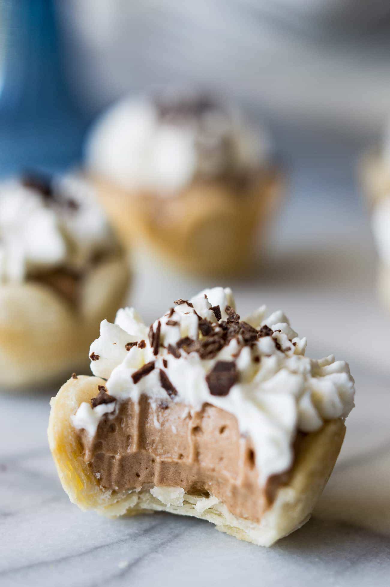 Mini French Silk Pies. Easy to make than you probably think and decadently DELICIOUS! Silky, creamy, chocolate bliss topped with homemade whipped cream. All in bite size mini pies!