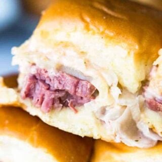 Easy to make slow cooker corned beef is layered on these sliders. Topped with Swiss cheese and a homemade Russian Dressing that makes these the BEST tasting Reuben Sliders around!!