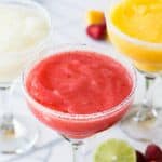 Ever wonder how to make restaurant style margaritas at home?! These fruity, slushy margaritas are made using real fruit and are an absolutely perfect cocktail for sipping on!