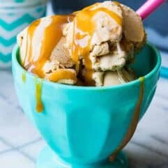 Ice cream bowl filled with homemade dulce de leche ice cream and topped with drizzles of caramel.
