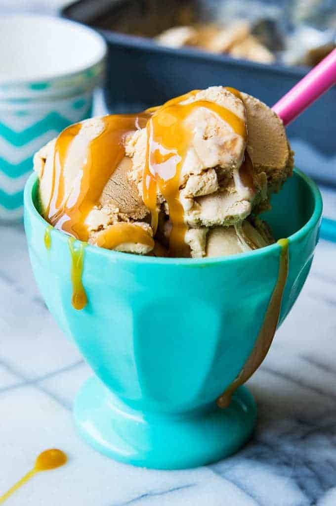 Ice cream bowl filled with homemade dulce de leche ice cream and topped with drizzles of caramel. 