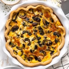 Mushroom quiche in a white ceramic pie dish.