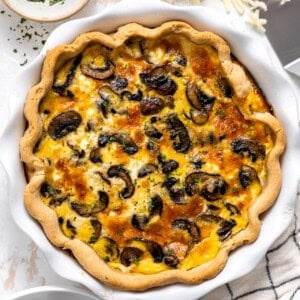 Mushroom quiche in a white ceramic pie dish.