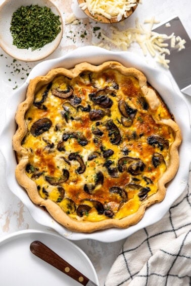 Mushroom quiche in a white ceramic pie dish.