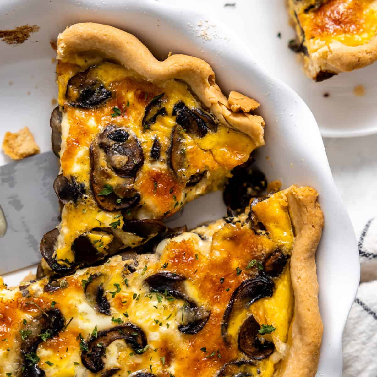 Sliced mushroom quiche in a pie dish.