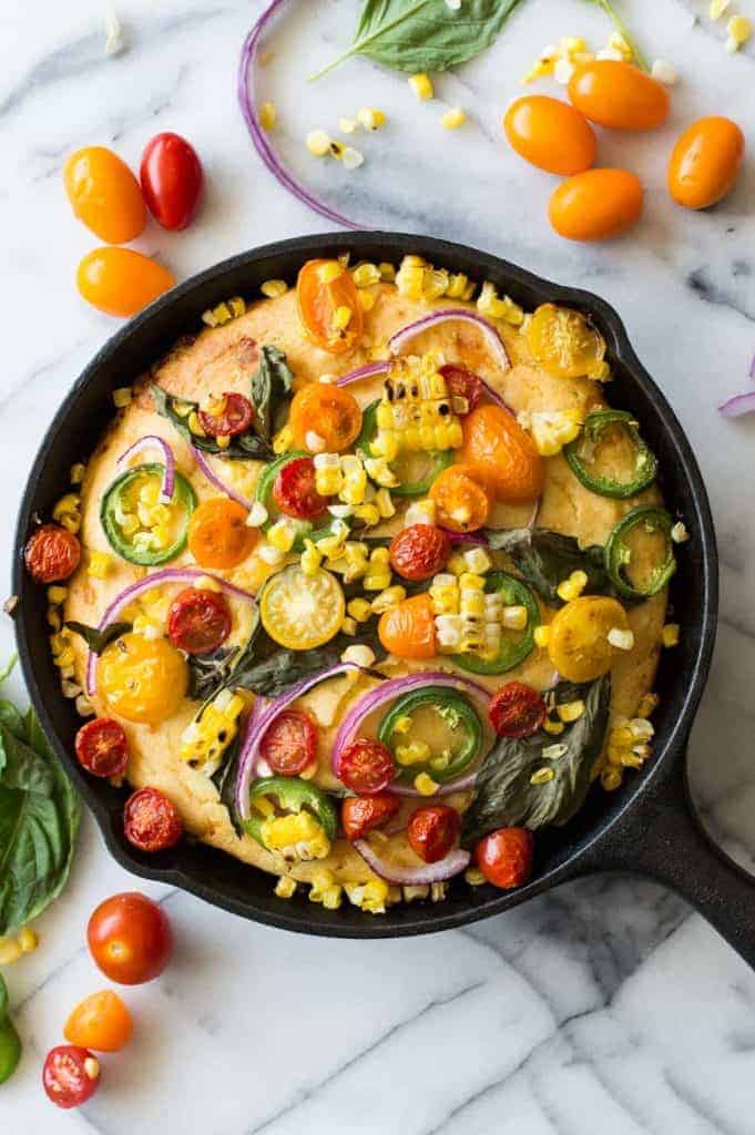 This cornbread is loaded with fresh grilled corn, cheese, and topped with farmers market finds! Tomato, jalapeño, red onion, fresh basil, and even more grilled corn! Make it your own by adding your own toppings!