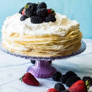 A whipped lemon mascarpone cream filling is layered with lightly sweetened crepes for a perfect dessert or brunch recipe!! Topped with lemon curd whipped cream and fresh berries!