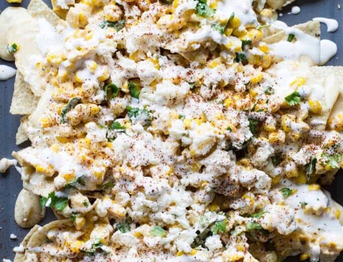 Mexican Street Corn Nachos! Chips loaded up with all the flavors of a classic mexican street corn and smothered with a creamy, spicy queso blanco.