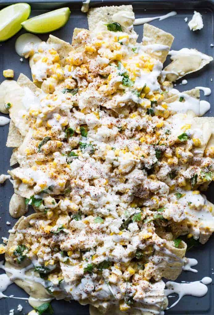 Mexican Street Corn Nachos! Chips loaded up with all the flavors of a classic mexican street corn and smothered with a creamy, spicy queso blanco.