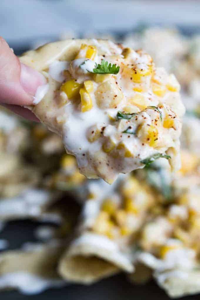 Mexican Street Corn Nachos! Chips loaded up with all the flavors of a classic mexican street corn and smothered with a creamy, spicy queso blanco.