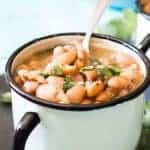 Charro Beans, or Cowboy Beans, are a classic Tex Mex side dish of pinto beans flavored with garlic, onion, and spiced up with some chiles. This version is made easy with the slow cooker! The perfect complement to any meal!