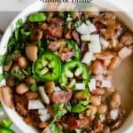 Charro beans topped with sliced jalapeno.