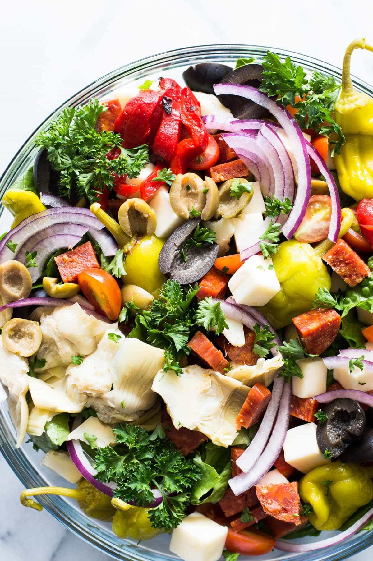 Antipasto Salad! The perfect side dish to go along with your Italian meals, loaded with artichoke hearts, roasted red peppers, olives, pepperoni, and fresh mozzarella! Not to mention drizzled with an easy to make vinaigrette made with pantry items! 