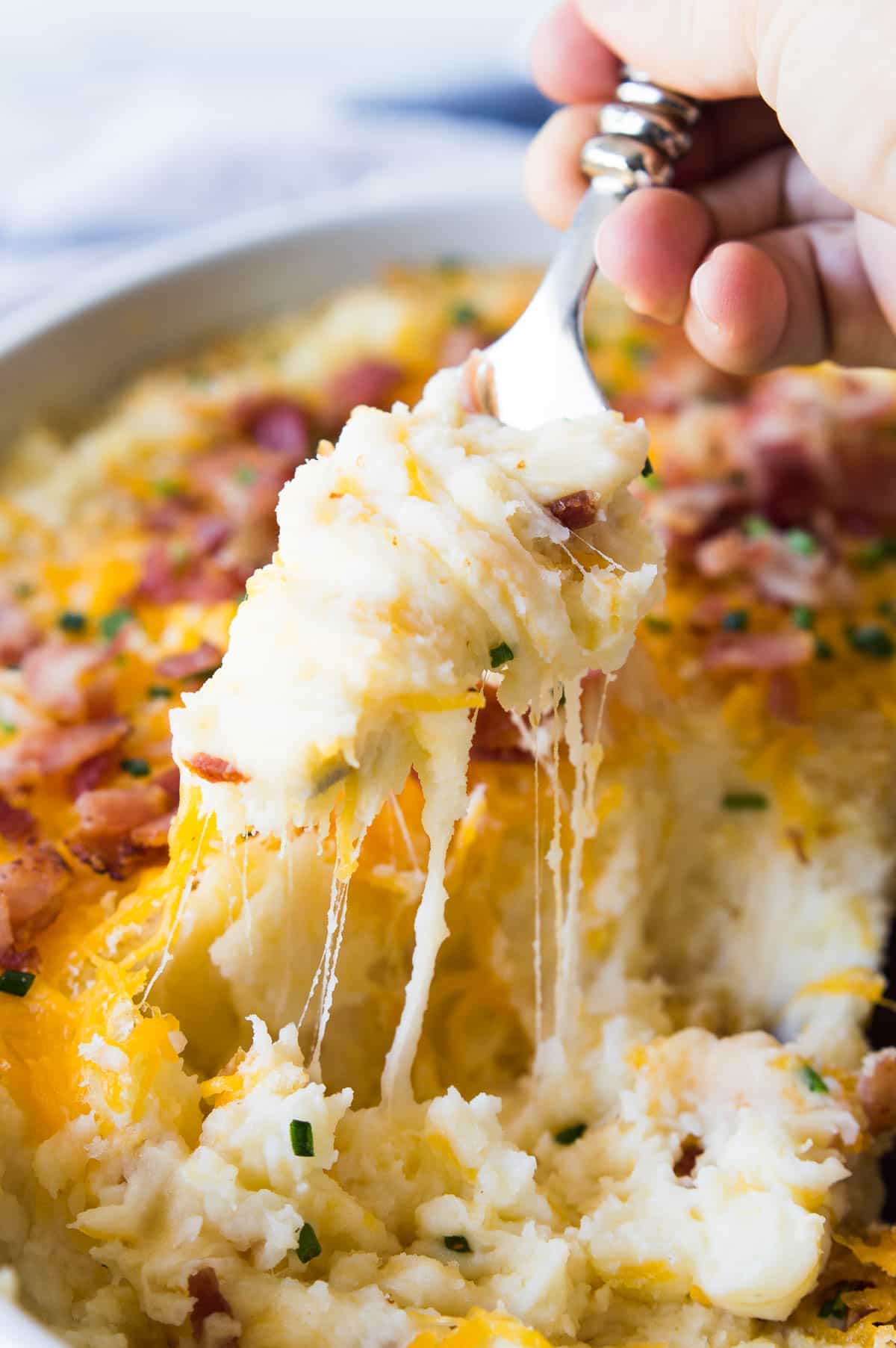 Mashed Potato Casserole. The creamiest, cheesiest mashed potatoes EVER! This easy to make side dish is loaded up with extra melty cheese, crispy bacon, and chives. The best part? You can make this dish ahead of time and then just pop it in the oven to heat back up! This dish will end up being the highlight of any meal!