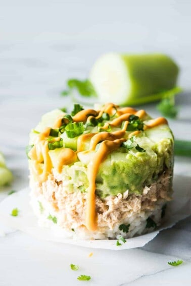 Salmon Stacks!! This super simple recipe is the perfect light and fresh snack, lunch, or light dinner! Sure to impress!!! This dish has layers of fluffy cilantro, lime rice. Salmon mixed with a spicy mayo. Smooth and creamy avocado. And fresh and cool cucumber. Forget getting that pricey sushi! Make this scrumptious snack at home!