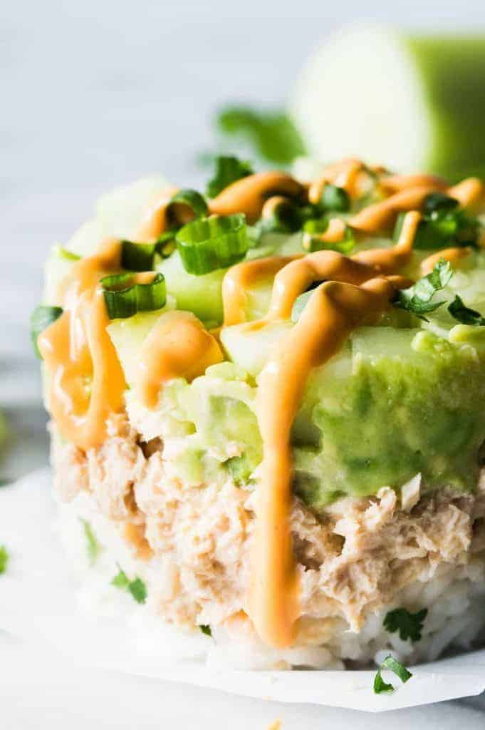 Salmon Stacks!! This super simple recipe is the perfect light and fresh snack, lunch, or light dinner! Sure to impress!!! This dish has layers of fluffy cilantro, lime rice. Salmon mixed with a spicy mayo. Smooth and creamy avocado. And fresh and cool cucumber. Forget getting that pricey sushi! Make this scrumptious snack at home!