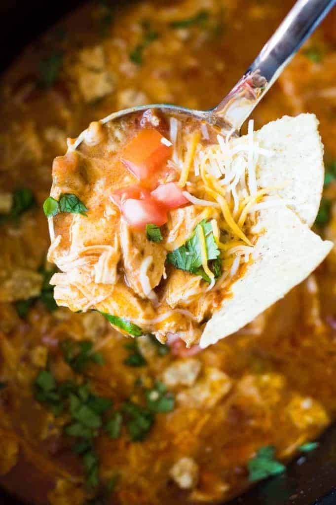 Slow Cooker King Ranch Chicken Soup. This EASY soup tastes just like the beloved King Ranch Chicken Casserole. Loaded with cheese, juicy chunks of chicken, and tons of flavor! Simply load up the slow cooker and let this soup simmer during the day so you can enjoy this for dinner! 