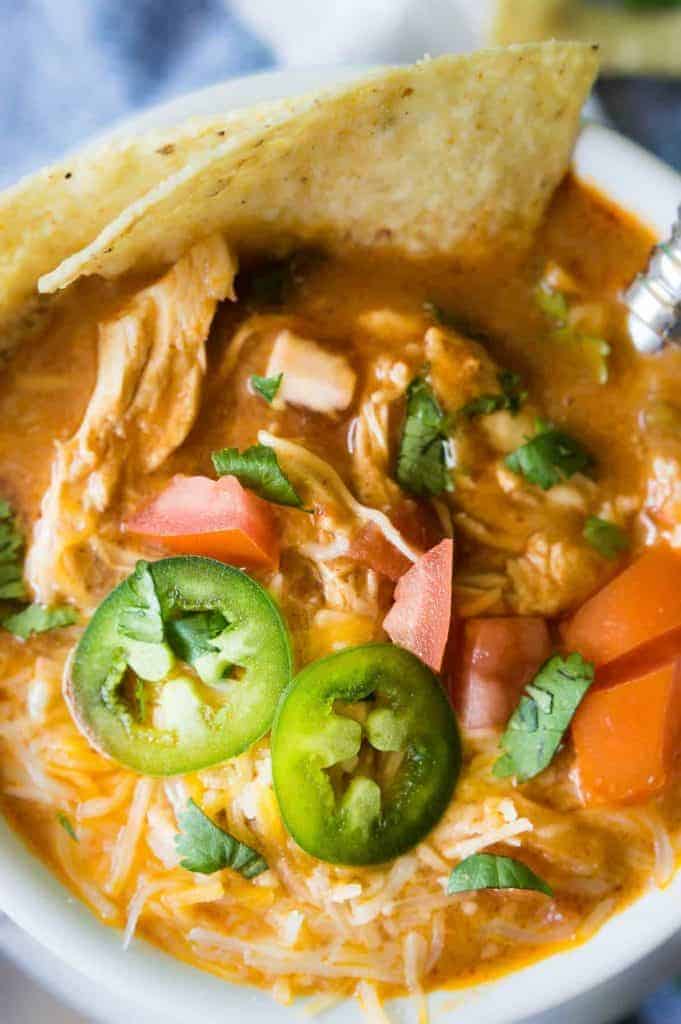 Slow Cooker King Ranch Chicken Soup. This EASY soup tastes just like the beloved King Ranch Chicken Casserole. Loaded with cheese, juicy chunks of chicken, and tons of flavor! Simply load up the slow cooker and let this soup simmer during the day so you can enjoy this for dinner! 