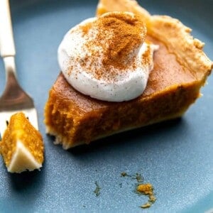 Slice of butternut squash pie with a bite taken out with a fork.