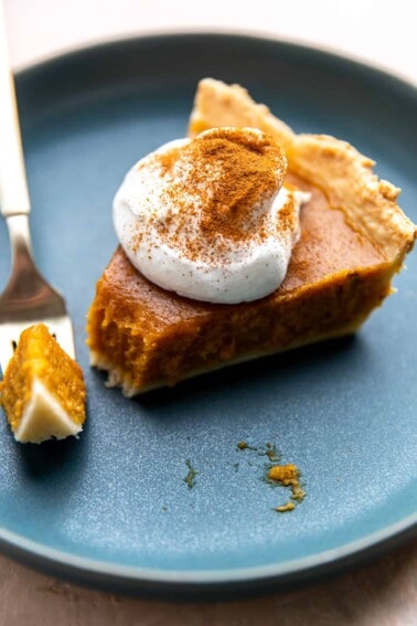 Slice of butternut squash pie with a bite taken out with a fork.
