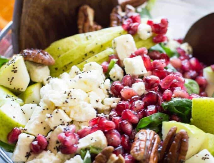 Pear & Pomegranate Salad with Orange Poppyseed Vinaigrette. This salad is loaded up with juicy pear, tart pomegranate, pecans, feta, all on a bed of fresh baby spinach and drizzled with a citrus orange poppyseed vinaigrette. This beautiful salad will be the highlight of any meal! The colors are perfect for any Holiday spread too!